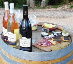 Pause dégustation lors d'une randonnée : bouteilles de vins régionales, charcuterie et produits régionaux
