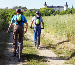 Deux randonneurs en E-scoot de dos, à travers les chemins du Gard