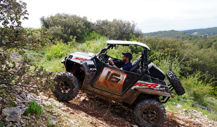 Un radonneur en quad gravit une pente