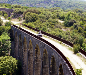 Photo aérienne d'un quad qui randonne sur un pont du Gard